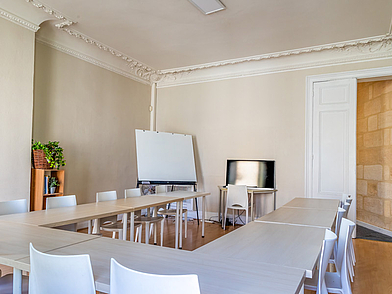 Freundlicher Klassenraum in Bordeaux mit U-Form-Tischen für interaktiven Französischunterricht auf Sprachreise.
