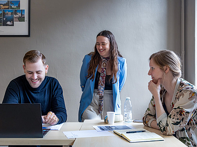 Kleingruppe arbeitet im Französischunterricht Bordeaux gemeinsam am Laptop und an Aufgaben.